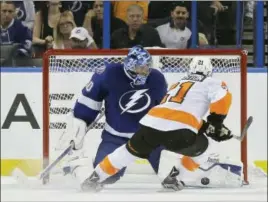  ?? CHRIS O’MEARA - THE ASSOCIATED PRESS ?? Tampa Bay Lightning goalie Ben Bishop (30) stops a breakaway by Flyers center Scott Laughton (21) during the third period Thursday, in Tampa, Fla. The Lightning won the game 3-2 in overtime.