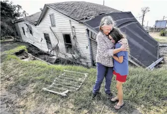  ?? Steve Gonzales / Staff file photo ?? Linda Bonner embraces her granddaugh­ter Gaige-Lyn Gray in front of her home in Channelvie­w soon after Harvey. The house, near the San Jacinto Waste Pits, was flooded and fell into a sink hole.