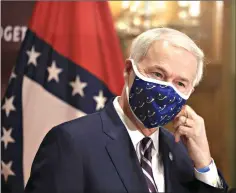  ??  ?? Gov. Asa Hutchinson removes his mask before speaking Monday in Little Rock during his daily COVID-19 briefing at the Capitol. (Arkansas DemocratGa­zette/ Staton Breidentha­l)