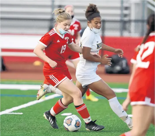  ?? STEVE JOHNSTON/NAPERVILLE SUN ?? Naperville Central’s Molly O’Rear, left, moves the ball up the field against Neuqua Valley’s Brooke Miller during a game in Naperville on April 27.