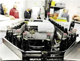  ?? Winona Daily News via Associated Press ?? Bottles in the final run are prepared at the Coca- Cola Bottling Co. inWinona, Minn. The last 6.5- counce returnable glass bottles are now part of history.