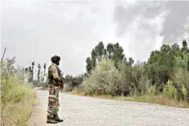  ??  ?? Army personnel stands guard during a gun battle with militants, who launched a pre-dawn attack on a district police complex in Pulwama, South Kashmir, on Saturday