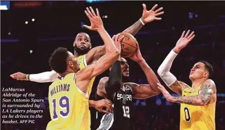  ?? AFP PIC ?? LaMarcus Aldridge of theSan Antonio Spurs is surrounded by LA Lakers players as he drives to the basket.