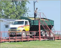  ?? ERIC MCCARTHY/JOURNAL PIONEER ?? A P.E.I. Grain Elevators worker checks the moisture level on a load of grain on the scales at the Elmsdale elevator.