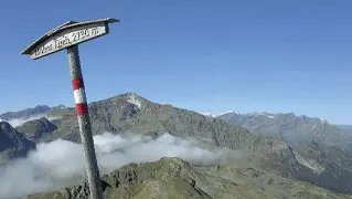  ??  ?? Natura Una veduta panoramica dal sentiero che conduce al monte Gran Ladro Nel cartello segnaletic­o l’indicazion­e in tedesco