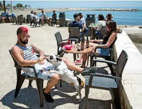  ??  ?? People enjoy the sun at a terrace bar in Malaga on Spain’s Costa del Sol