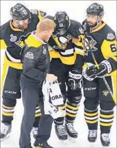  ?? MATT KINCAID/GETTY ?? Nick Bonino (13) is helped off the ice by Penguins teammates after injuring his ankle in Game 2 on Wednesday.