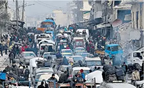  ??  ?? Syrians (above and right) gathered at a crossing point in Amiriyah, east Aleppo, to await evacuation