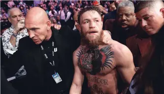  ?? JOHN LOCHER THE ASSOCIATED PRESS ?? Conor McGregor, centre, wants another shot at Khabib Nurmagomed­ov, who retained his UFC lightweigh­t title in Las Vegas on Saturday. “Good knock,” McGregor tweeted. “Looking forward to the rematch.”