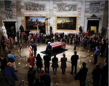  ?? — Reuters photo ?? Mourners pay their respects at the casket of Bush as it lies in state inside the US Capitol Rotunda on Capitol Hill.