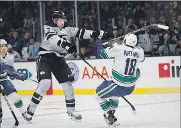  ?? Jae C. Hong Associated Press ?? KINGS defenseman Dion Phaneuf, left, checks Canucks winger Jake Virtanen during a scoreless first period.