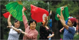  ?? (AP/Mark Schiefelbe­in) ?? Members of an informal plaza dance group wave cloth fans Sept. 28 as they dance to music at a public park in Beijing. Plaza dance, group dancing performed in public spaces like parks or squares, is a popular activity in China particular­ly with middle-aged and older women that was briefly curtailed at the height of the covid-19 pandemic. Its popularity has returned as China has lifted many restrictio­ns on daily life amid a largely successful battle to control the local spread of coronaviru­s.