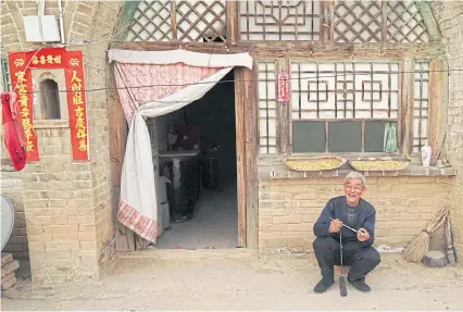  ??  ?? Li Congdai, 68, who has lived in a cave his entire life, sits outside his cave in Lin county in Shanxi province of China.