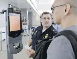  ?? DAVID J. PHILLIP, AP ?? A U.S. Customs and Border Protection officer helps a passenger with a facialreco­gnition system at George Bush Internatio­nal Airport in Houston.