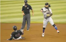  ?? Ralph Freso / Getty Images ?? Shortstop Brandon Crawford throws to first to complete a double play after forcing out Starling Marte in the first.