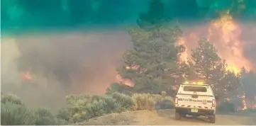  ??  ?? File photo shows flames rise from a treeline near an emergency vehicle during efforts to contain the Spring Creek Fire in Costilla County, Colorado, US. — Reuters photo