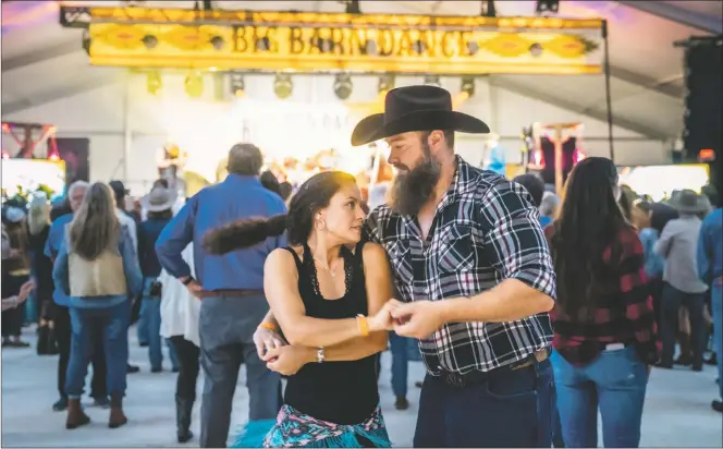  ?? NATHAN BURTON/Taos News ?? Barbara Burket and Bart Hancock spin across the floor during the Big Barn Dance on Saturday (Sept. 10).