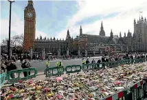  ?? PHOTO: REUTERS ?? Workmen fence off floral tributes in Parliament Square, following the attack in Westminste­r last week, in London.