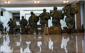  ??  ?? Troops move inside the Capitol Visitor’s Center to reinforce security at the Capitol in Washington Wednesday.