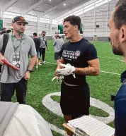  ?? Rob Maaddi/Associated Press ?? Welsh rugby star Louis Rees-Zammit, center, speaks to NFL scouts following pro day for NFL Internatio­nal Player Pathway prospects held at the University of South Florida on Wednesday in Tampa, Fla.