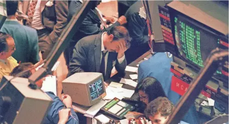  ?? AFP/GETTY IMAGES ?? A trader on the floor of the New York Stock Exchange reacts to the Dow’s 22.6% drop on Oct. 19, 1987.