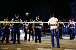  ?? ARMANDO L. SANCHEZ / CHICAGO TRIBUNE ?? A bystander watches as officers respond after shots were fired at and by the police in the Austin neighborho­od early July 4 in Chicago. Neither the suspect or officer was shot during the incident.