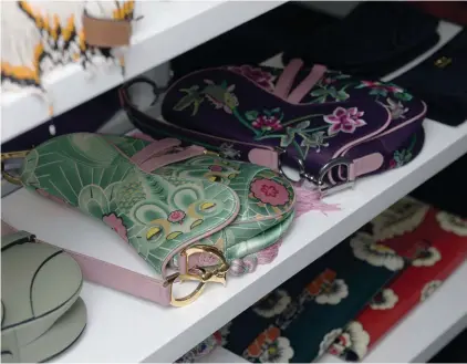  ??  ?? Tina's collection of Dior saddle bags mizes the older printed versions with the new