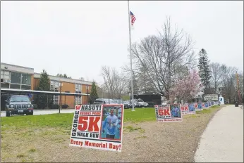  ?? Photo by Joseph B. Nadeau ?? Signs advertisin­g the upcoming George Nasuti Novans Pride 5K line the road outside Woonsocket High School.