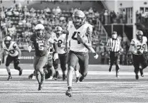  ?? Terrance Williams / Associated Press ?? Air Force quarterbac­k Haaziq Daniels runs for a second-half touchdown against Navy on Saturday. The Falcons are 2-0.