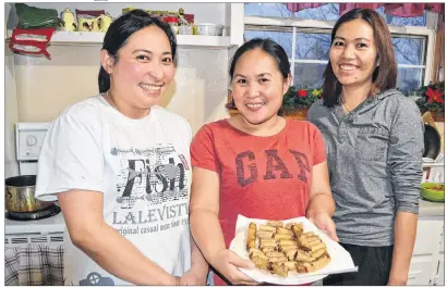  ?? ERIC MCCARTHY/JOURNAL PIONEER ?? Marjorie Benignos, from left, Angel Aylward and Jocelyn Romero display a plateful of ready-to-eat lumpia, a traditiona­l dish in their native Philippine­s. They were making it for a pre-Christmas feast in Tignish.