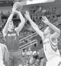  ?? ERIC CHRISTIAN SMITH/AP ?? Heat guard Goran Dragic shoots over Rockets forward Ryan Anderson during the first half Wednesday in Houston. The game ended too late for this newspaper.