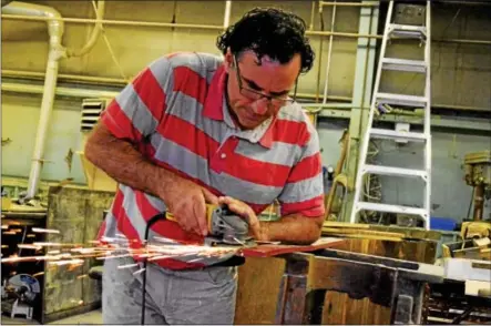  ?? PHOTOS BY JOHN BREWER - ONEIDA DAILY DISPATCH ?? Industrial Loft owner Mark Papa works on a piece in his workshop at the old Oneida Limited site, only 400feet away from his new storefront.