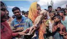  ?? — Reuters ?? Hamida, a Rohingya refugee woman, weeps as she holds her 40-day-old son after he died as their boat capsized before arriving on shore in Shah Porir Dwip, Teknaf, Bangladesh, on September 14, 2017.