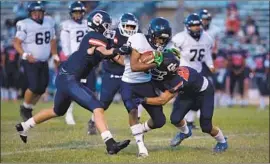  ?? Jason Armond Los Angeles Times ?? BIRMINGHAM running back Tyler Smith tries to shake off Chatsworth defenders in the season finale for both teams in a most unusual spring football season.