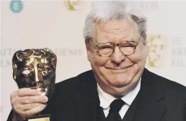  ??  ?? 0 Film director, producer and writer Alan Parker poses with his BAFTA fellowship award in 2013