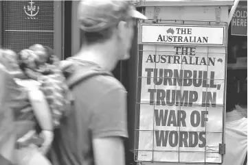  ??  ?? A pedestrian looks at a newspaper headline regarding Trump and Turnbull in central Sydney, Australia. — Reuters photo