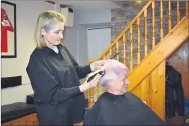  ?? (Photo: Katie Glavin) ?? CLOSE CALL - Raimonda Vitkevicie­ne of The Barber Shop, Fermoy shaving Patty Smyth’s head in aid of Marymount Hospice.