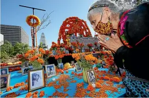  ?? AP ?? Day of the Dead altar maker Ofelia Esparza, 88, prays for family members who died in 2020 at an altar she helped to create in Grand Park, Los Angeles. The annual Mexican tradition is harder this year for Latino families in the US affected by the coronaviru­s pandemic.