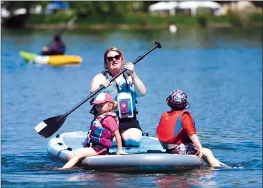  ?? NEWS-SENTINEL FILE PHOTOGRAPH ?? Therra Wilson paddles Charisma Aalund and son Clayton Wilson, all of Sacramento, during Paddle Fest at Lodi Lake on Saturday, April 21, 2018. Headwaters Kayak will be offering a Mother’s Day Paddle this Sunday at Lodi Lake.