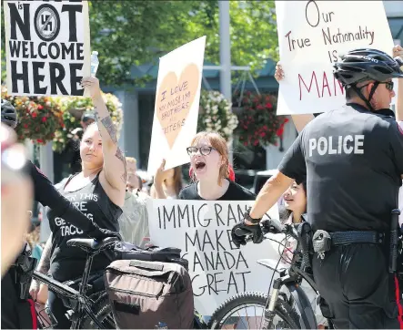  ?? DARREN MAKOWICHUK ?? A large police presence keeps the peace as protesters confront members of an anti-Islam group at city hall Sunday.