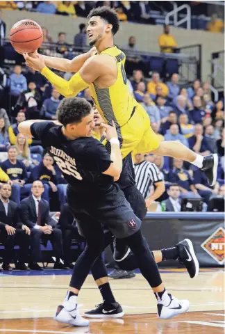  ?? MARK HOFFMAN / MILWAUKEE JOURNAL SENTINEL ?? Marquette guard Markus Howard goes to the basket and draws a foul on Harvard guard Corey Johnson during the first half.