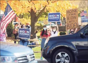  ?? Ned Gerard / Hearst Connecticu­t Media ?? Supporters of Joe Biden stand and cheer at the Sherman Green in Fairfield on Saturday after it was announced that Biden had defeated President Donald Trump in the 2020 presidenti­al election.