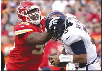  ?? (AP file photo) ?? Kansas City Chiefs All-Pro defensive tackle Chris Jones (left) hits Denver Broncos quarterbac­k Russell Wilson during their Jan. 1 matchup. Players such as Jones, who had 151/2 sacks this season, should make a difference today in Super Bowl LVII as the game will come down to which team controls the line of scrimmage.