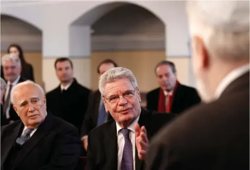  ?? (Alkis Konstantin­idis/Reuters) ?? GERMAN THEN-PRESIDENT Joachim Gauck (C) speaks to the head of the Greek-Jewish community of Ioannina during his 2014 visit to their synagogue in northweste­rn Greece, as tribute to the dozens massacred by the Nazis.