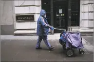  ?? Getty Images ?? A mail carrier walks along Wall Street as the coronaviru­s keeps financial markets and businesses mostly closed on May 8. More than 36 million Americans have been forced out of work by the pandemic.