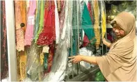  ?? HANAA SEPTIANA/JAWA POS ?? LARIS MANIS: Siti Suchoiroti menutup lemari yang penuh dengan kostum.