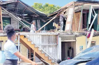  ?? PHOTO BY SHANNA MONTEITH ?? A demolition crew dismantles a derelict building in Morant Bay which has featured in the discovery of skeletal remains over two days.