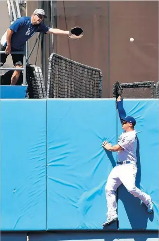  ?? Wally Skalij Los Angeles Times ?? THE DODGERS’ Joc Pederson soars into the outfield fence in a failed effort to prevent a home run by the Diamondbac­ks’ Chris Iannetta during the third inning.