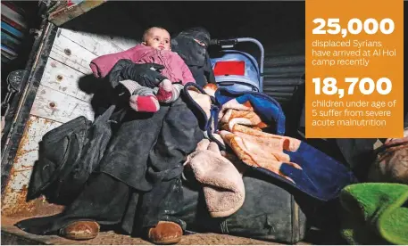  ?? AFP ?? A woman sits in the back of a truck carrying an infant among pieces of luggage near the Omar oilfield in the eastern Syrian Deir Al Zor province on January 25 upon arriving with other fleeing families from remaining pockets held by Daesh.