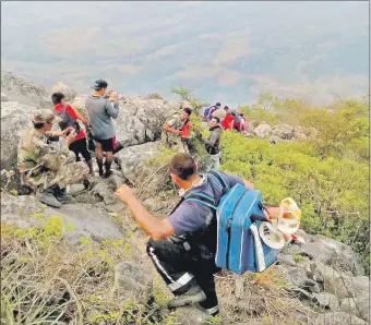  ??  ?? Los estudiante­s bajaron del cerro con ayuda de policías y bomberos, de fondo, el humo.